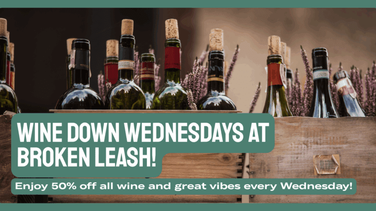 Glass of red wine at a table with a dog nearby at a dog-friendly bar in North Charleston