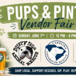 Guests shopping local vendors and meeting adoptable dogs at Pups and Pints Vendor Fair.